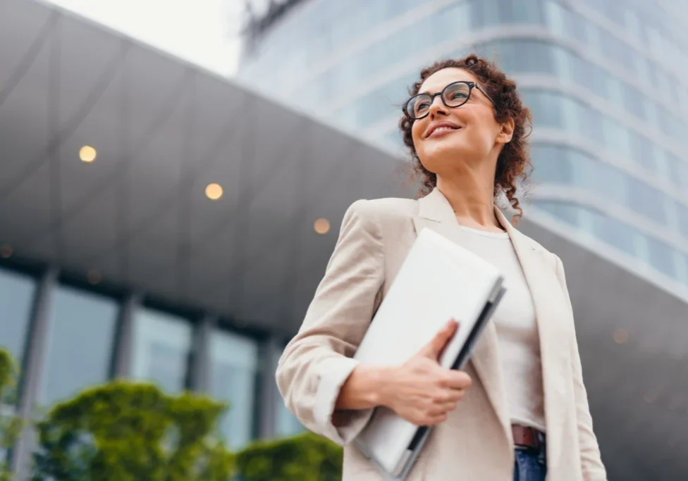 Professional woman smiling near modern architecture