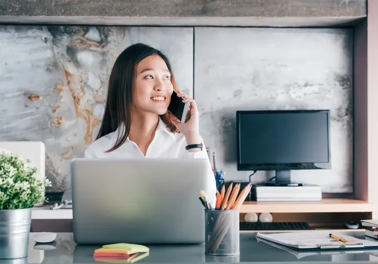 Woman talking on phone at desk