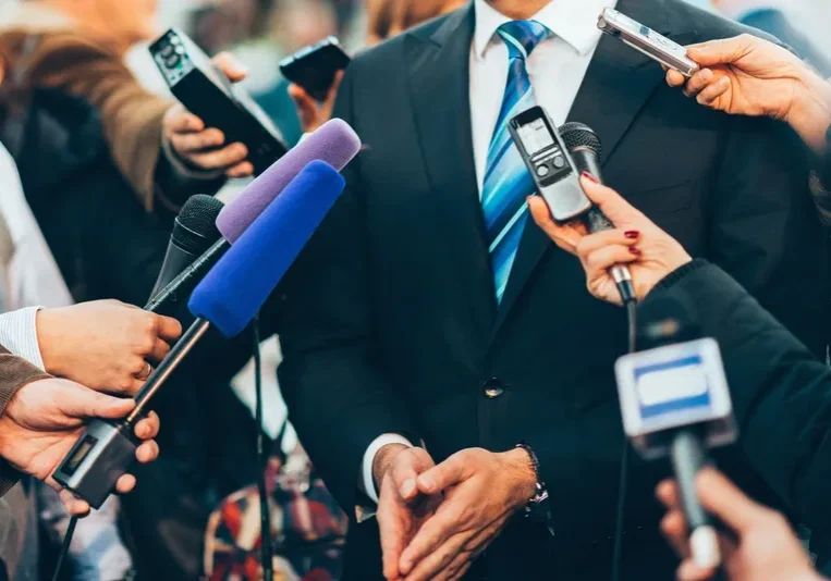 Microphones surrounding a businessman